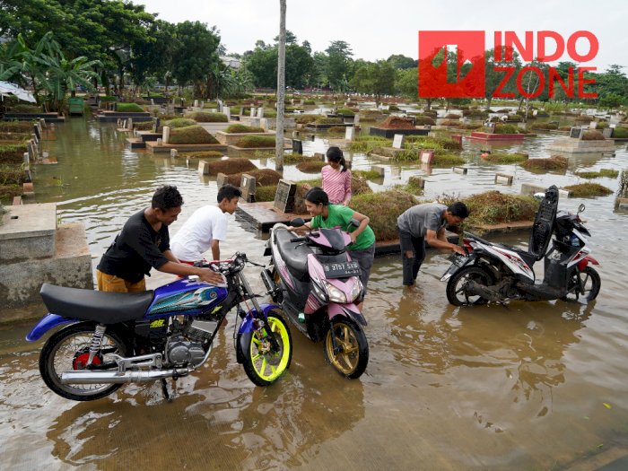 FOTO: Banjir di TPU Tanah Kusir Dimanfaatkan Warga untuk Cuci Motor
