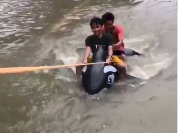 Viral! Dua Pria Ini Menjajal Balon Lumba-Lumba Sewaktu Terjang Banjir