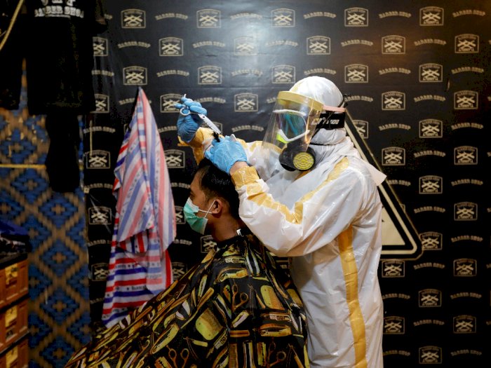FOTO: Cegah Virus Corona, Tukang Cukur Ini Pakai Baju APD Buatan Sendiri