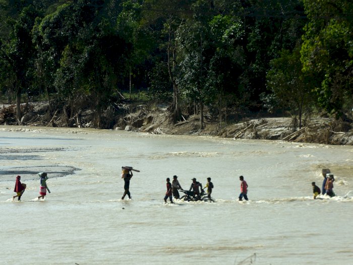 FOTO: Pengungsi Masamba Harus Menyeberangi Sungai untuk Dapat Bantuan