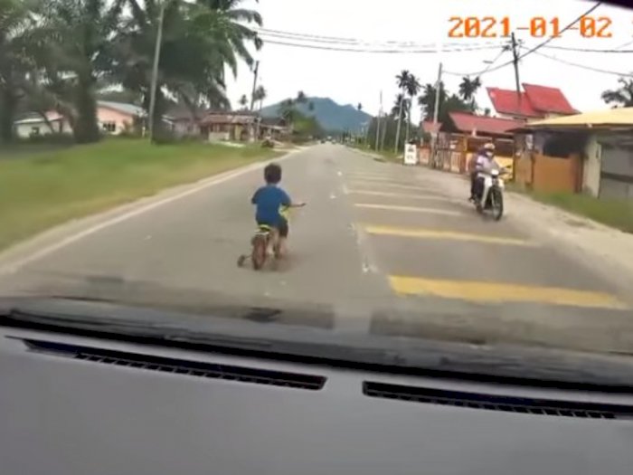 Seorang Bocah Laki-laki Dibiarkan Bersepeda Di Tengah Jalan Tanpa Pengawasan Orang Dewasa