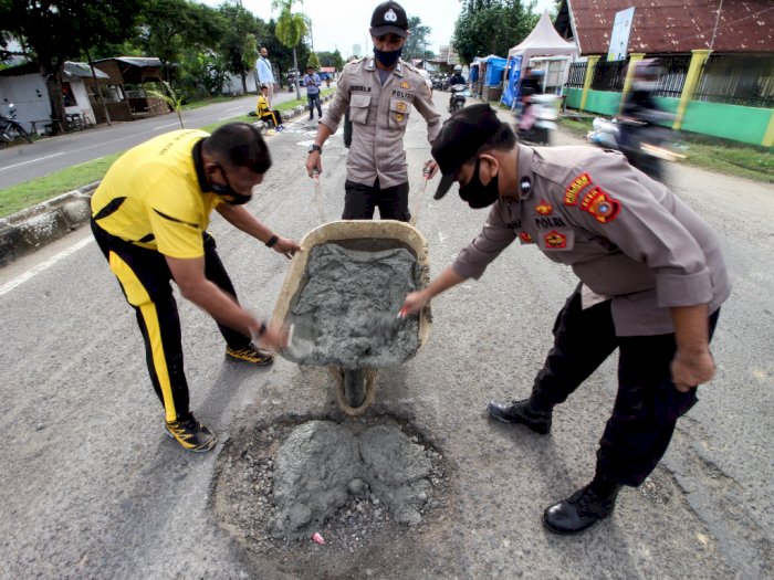 FOTO: Aksi Polisi Tambal Lubang Jalan di Aceh