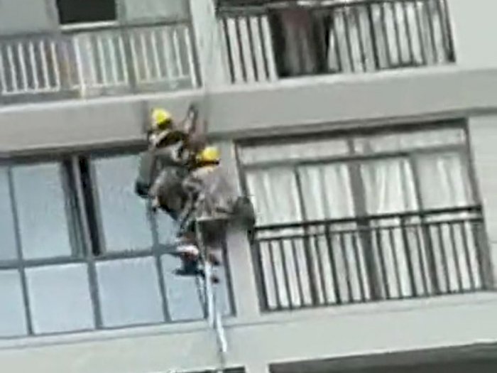 Momen Dua Pekerja Konstruksi Tergantung di Kawat Menabrak Bangunan Setelah Angin Kencang