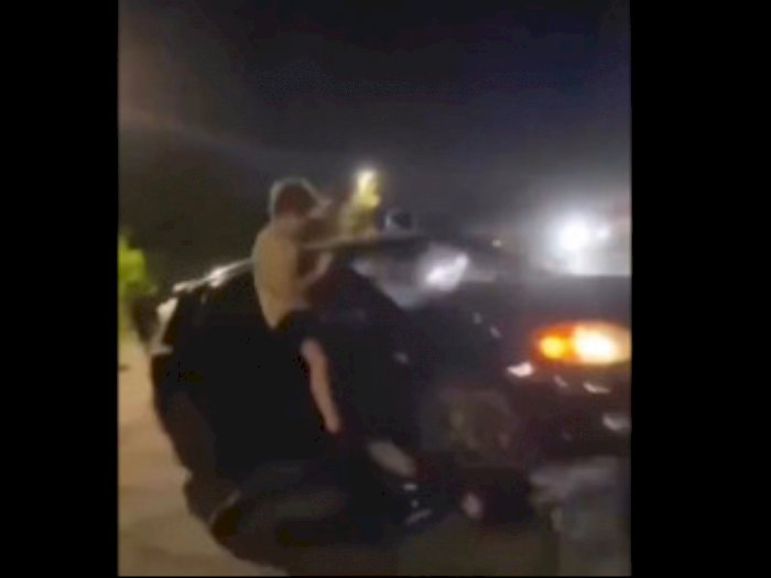 Seorang Pria Lakukan Aksi Berbahaya! Sengaja Terjatuh saat Gelantungan dan Terlindas Mobil