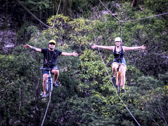 Naik Sepeda di Atas Tali Setinggi 80 Meter dengan Pemandangan Sungai Biru, Berani Coba?