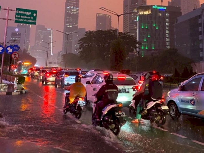 Potret Pemotor Berjuang Lintasi Sudirman Macet di Tengah Hujan Lebat dan Langit Jingga