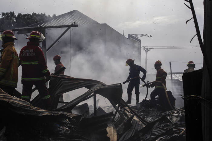ANTARA FOTO/Yulius Satria Wijaya Petugas pemadam kebakaran memadamkan sisa kebakaran gudang barang bekas di Pondok Rajeg