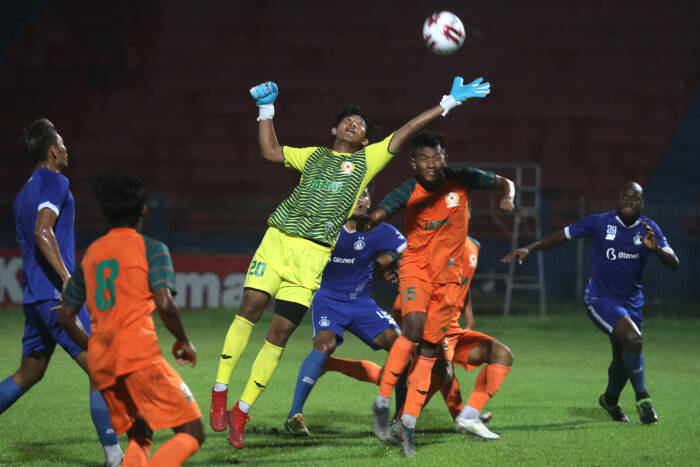 Kiper tim sepak bola Pekan Olahraga Nasional (PON) Jawa Timur Eko Saputro (tengah) mencoba menangkap bola