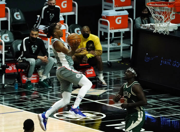 Guard Los Angeles Clippers Terance Mann (14) bergerak ke keranjang melawan guard Milwaukee Bucks Jrue Holiday (21). REUTERS/Gary A. Vasquez Guard Los Angeles Clippers Terance Mann (14) bergerak ke keranjang melawan guard Milwaukee Bucks Jrue Holiday (21)