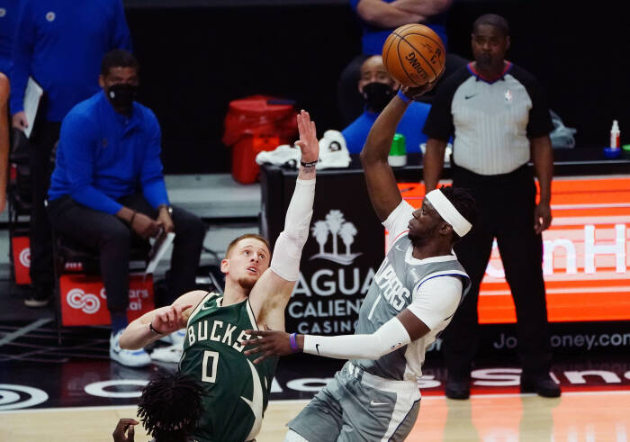 Guard Los Angeles Clippers Reggie Jackson (1) menembak melawan guard Milwaukee Bucks Donte DiVincenzo (0). REUTERS/Gary A. Vasquez Guard Los Angeles Clippers Reggie Jackson (1) menembak melawan guard Milwaukee Bucks Donte DiVincenzo (0)