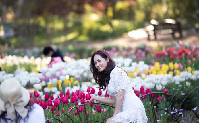 REUTERS/Mario Anzuoni Seorang pengunjung berpose untuk foto dengan tambalan tulip di Taman Descanso di La Canada Flintridge