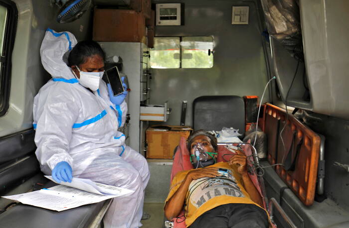 Seorang paramedis berusia 31 tahun, memeriksa laporan medis seorang pasien di dalam ambulans sebelum menuju ke rumah sakit penyakit coronavirus (COVID-19), di tengah penyebaran COVID-19 di Ahmedabad, India, 29 April 2021. Gambar diambil 29 April 2021. (REUTERS/Amit Dave) kasus corona di india