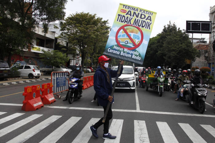 ANTARA FOTO/Maulana Surya Relawan mengusung poster bertuliskan Terima Kasih Anda Tidak Mudik saat aksi di Jalan Slamet Riyadi