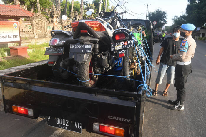 Polisi menghentikan pengendara mobil yang mengangkut barang di luar kebutuhan pokok (ANTARA FOTO/Nyoman Budhiana) Polisi menghentikan pengendara mobil yang mengangkut barang di luar kebutuhan pokokPolisi menghentikan pengendara mobil yang mengangkut barang di luar kebutuhan pokok