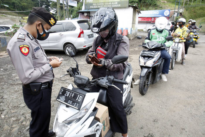 ANTARA FOTO/Yulius Satria Wijaya Polisi memeriksa kendaraan warga di perbatasan Cianjur dan Bogor