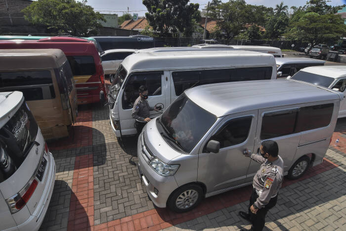 ANTARA FOTO/ Fakhri Hermansyah Petugas polisi memeriksa mobil travel gelap yang disita di halaman Polres Metro Kabupaten Bekasi