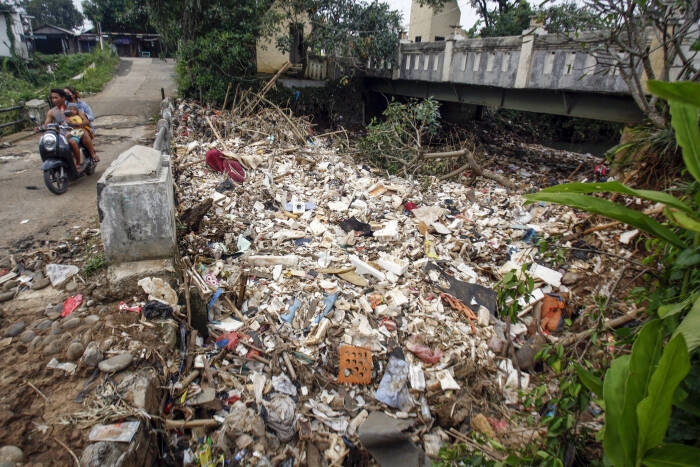 ANTARA FOTO/Yulius Satria Wijaya Warga melintas jembatan sungai Kali Baru yang tersumbat sampah