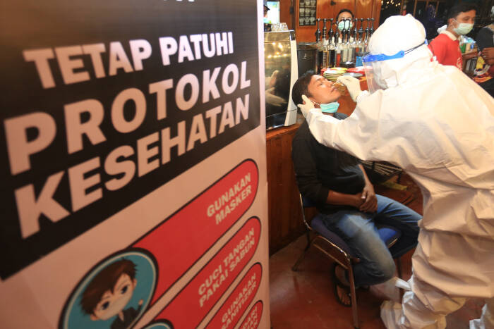 Petugas kesehatan melakukan tes swab antigen kepada salah satu karyawan warung kopi (ANTARA FOTO/Syifa Yulinnas) Petugas kesehatan melakukan tes swab antigen kepada salah satu karyawan warung kopi