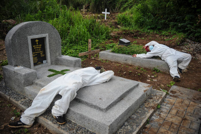 Sejumlah tenaga pikul beristirahat setelah memakamkan jenazah dengan protokol COVID-19 di TPU Cikadut (ANTARA FOTO/Raisan Al Farisi) Sejumlah tenaga pikul beristirahat setelah memakamkan jenazah dengan protokol COVID-19 di TPU Cikadut