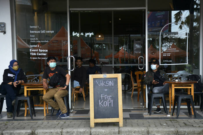 Warga yang sudah divaksin COVID-19 menunggu pembagian kopi gratis (ANTARA FOTO/Abriawan Abhe) Warga yang sudah divaksin COVID-19 menunggu pembagian kopi gratis