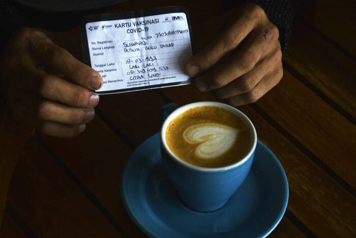 Warga yang sudah divaksin COVID-19 memperlihatkan kartu vaksin saat mendapatkan kopi gratis (ANTARA FOTO/Abriawan Abhe) Warga yang sudah divaksin COVID-19 memperlihatkan kartu vaksin saat mendapatkan kopi gratis