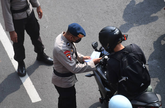 Anggota Polisi memeriksa dokumen warga saat melintasi titik penyekatan baru (ANTARA FOTO/Akbar Nugroho Gumay) Anggota Polisi memeriksa dokumen warga saat melintasi titik penyekatan baru