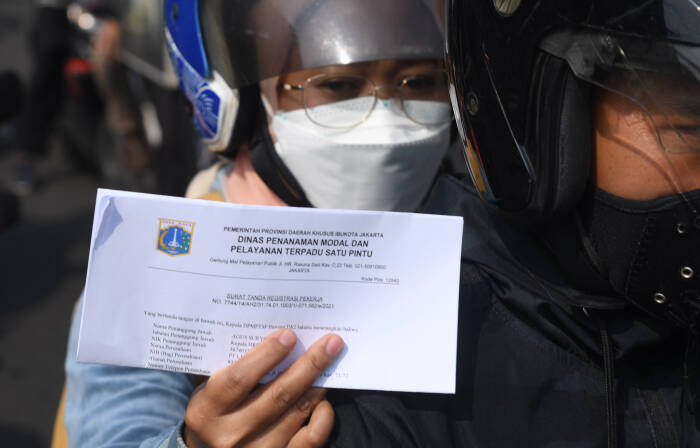 Warga menunjukkan dokumen saat melintasi titik penyekatan baru (ANTARA FOTO/Akbar Nugroho Gumay) Warga menunjukkan dokumen saat melintasi titik penyekatan baru