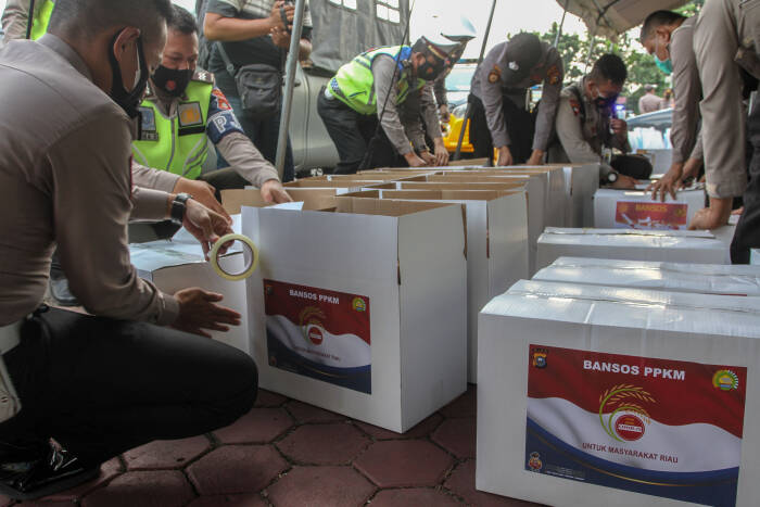 Petugas Kepolisian Daerah Riau mempersiapkan ratusan paket bantuan sosial (ANTARA FOTO/Rony Muharrman) Petugas Kepolisian Daerah Riau mempersiapkan ratusan paket bantuan sosial