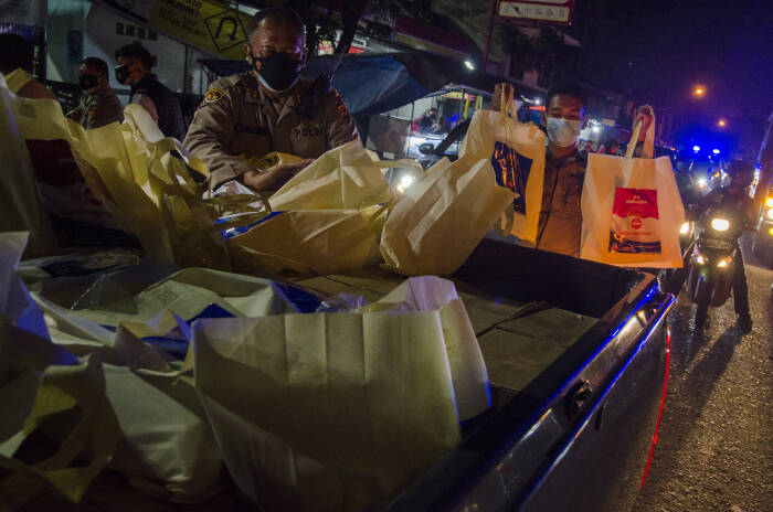 Anggota Kepolisian mengambil sejumlah paket bantuan sosial sembako untuk dibagikan kepada warga (ANTARA FOTO/Novrian Arbi) Anggota Kepolisian mengambil sejumlah paket bantuan sosial sembako untuk dibagikan kepada warga