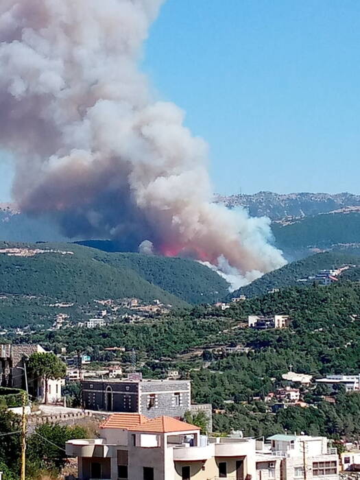 REUTERS/Mouarbes Jean Asap membumbung di atas kota Qobayat di Lebanon
