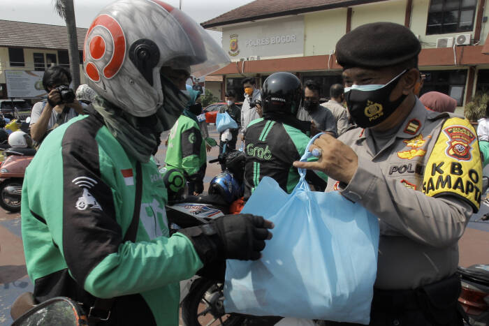 ANTARA FOTO/Yulius Satria Wijaya PEMBAGIAN PAKET SEMBAKO UNTUK PENGEMUDI OJEK DARING