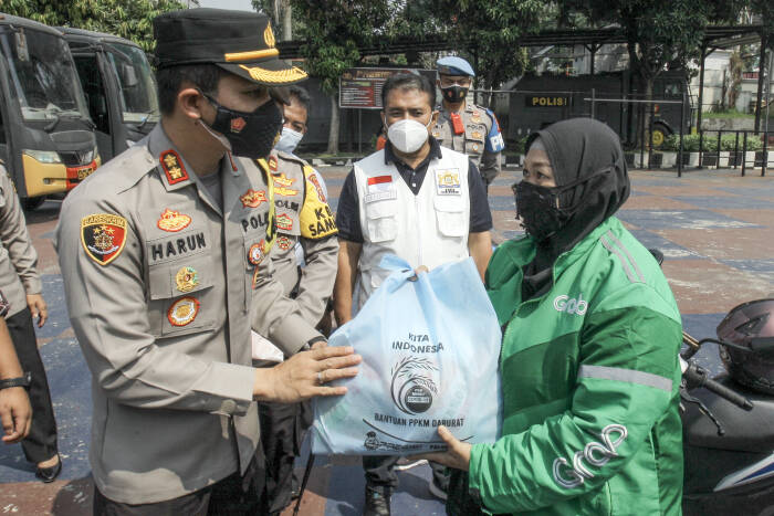 Kapolres Bogor AKBP Harun (kiri) membagikan paket sembako (ANTARA FOTO/Yulius Satria Wijaya) Kapolres Bogor AKBP Harun (kiri) membagikan paket sembako