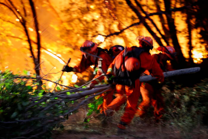 REUTERS/Fred Greaves petugas pemadam kebakaran bergerak menjauh dari rumah di River Fire dekat Grass Valley