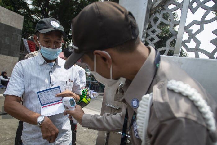 Petugas keamanan mengecek kartu vaksin warga (ANTARA FOTO/Aditya Pradana Putra) Petugas keamanan mengecek kartu vaksin warga