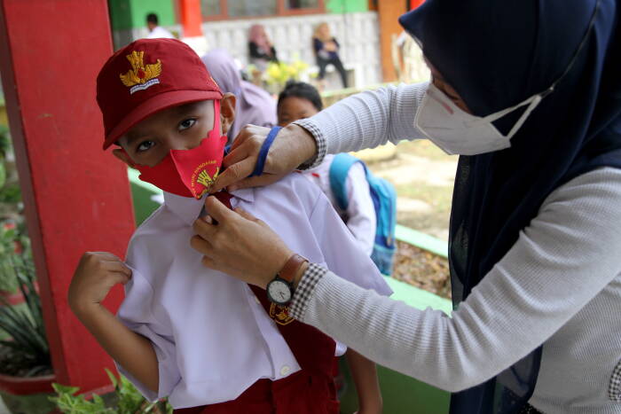 Orang tua murid merapikan seragam sekolah anaknya (ANTARA FOTO/Jojon) Orang tua murid merapikan seragam sekolah anaknya (ANTARA FOTO/Jojon)