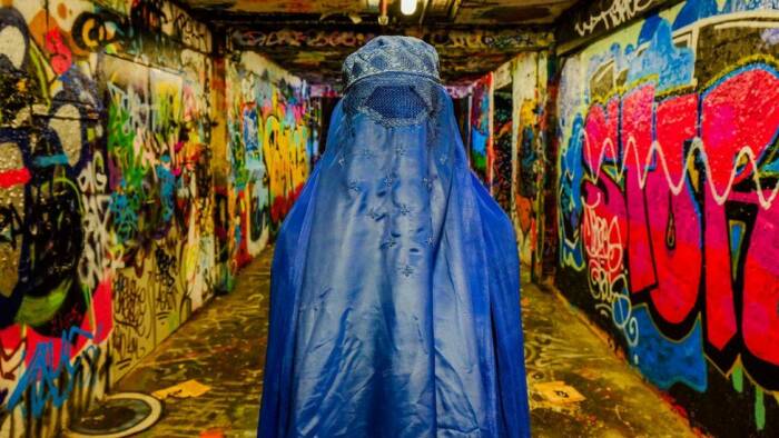Seorang wanita sedang mengenakan burqa di pusat pasar