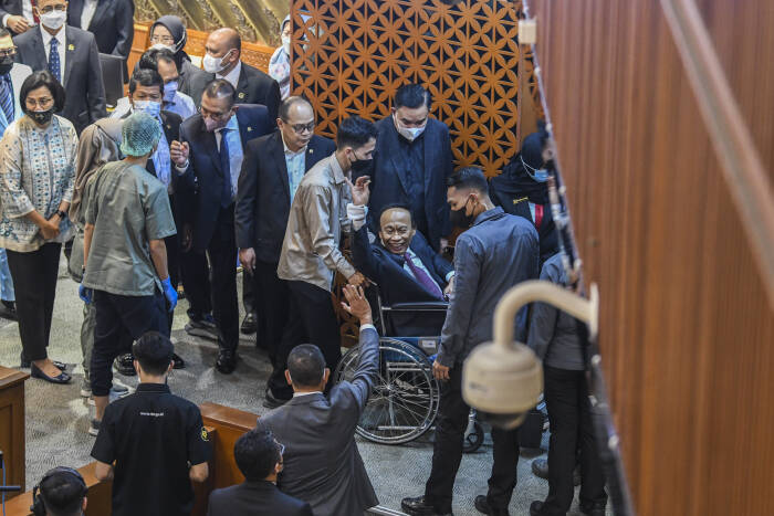 Muhidin Muhammad Said (tengah) meninggalkan ruang paripurna menggunakan kursi roda usai ambruk. (ANTARA FOTO/Galih Pradipta/hp)