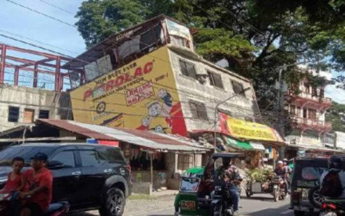 Kendaraan lewat di sebelah gedung yang rusak setelah gempa bumi di Bangued, Abra, Filipina, pada 27 Juli 2022. (FOTO A: The Strait Times/EPA-EFE)