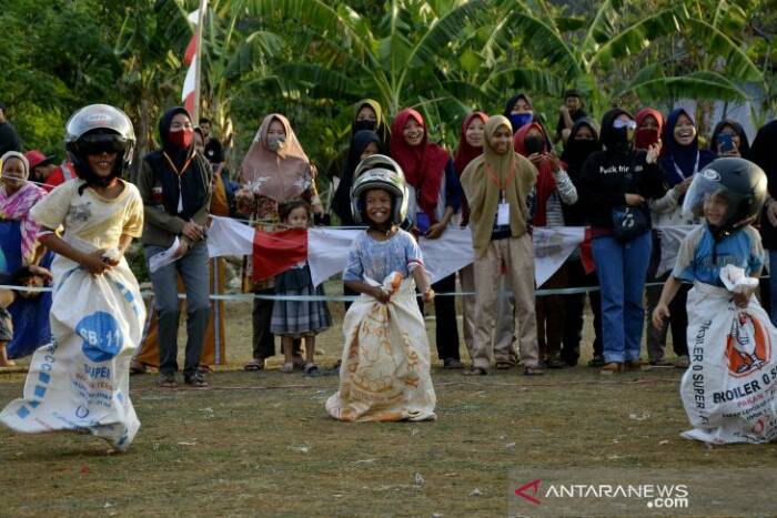 Anak-anak mengikuti lomba balap karung sambil menggunakan helm saat Festival Permainan Tradisional di Desa Simbang, Kabupaten Maros, Sulawesi Selatan, Minggu (13/9/2020). (ANTARA FOTO/Abriawan Abhe).