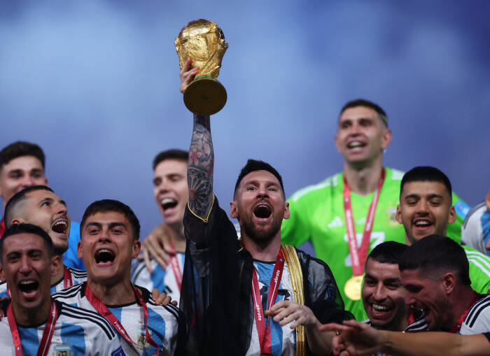 Kapten Timnas Argentina, Lionel Messi, mengangkat trofi Piala Dunia (REUTERS/Carl Recine) Lionel Messi
